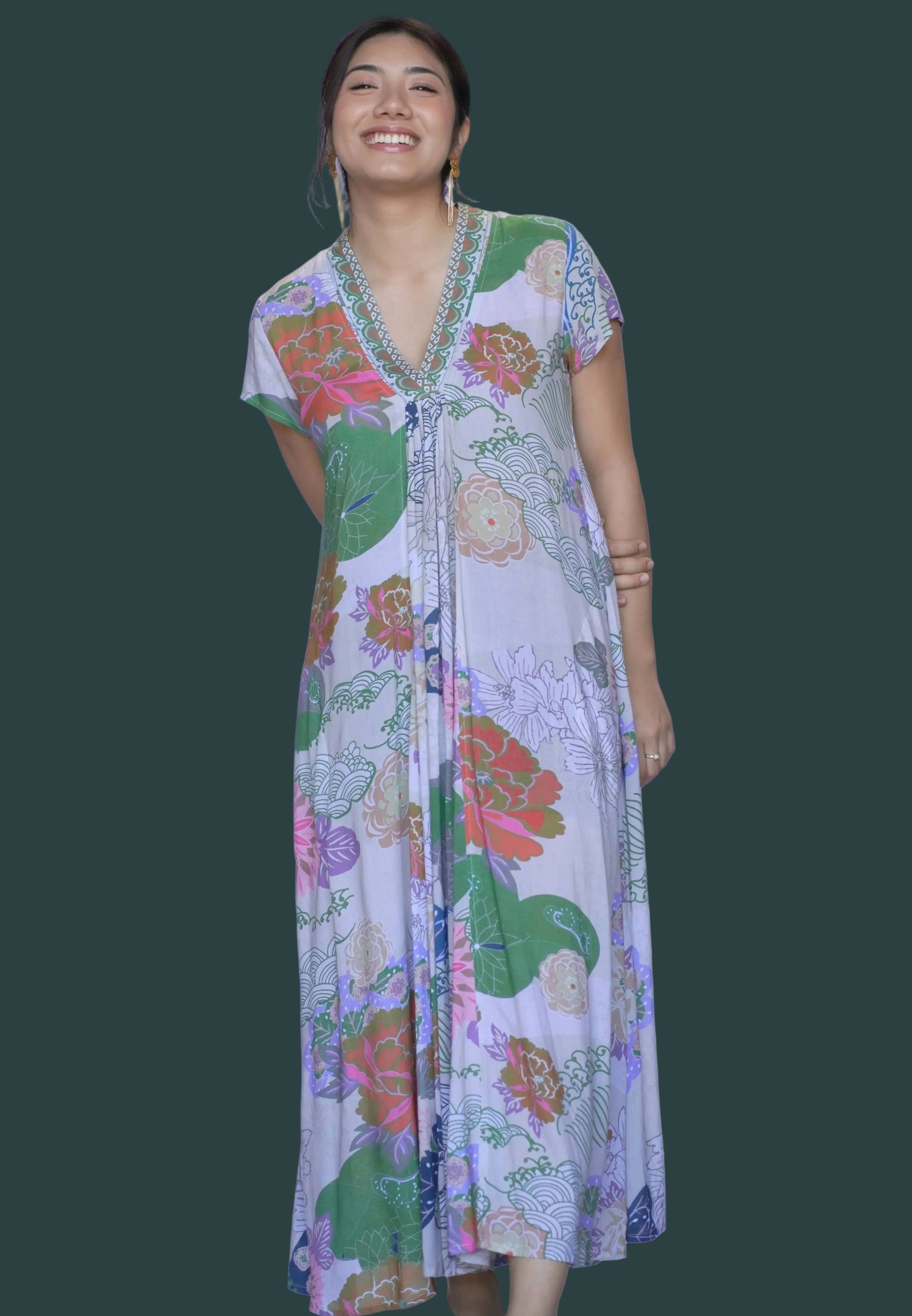 Woman wearing a colorful floral dress against a white background