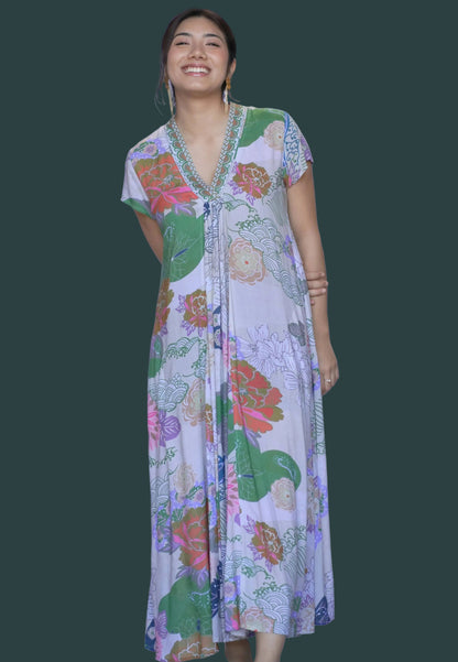 Woman wearing a colorful floral dress against a white background