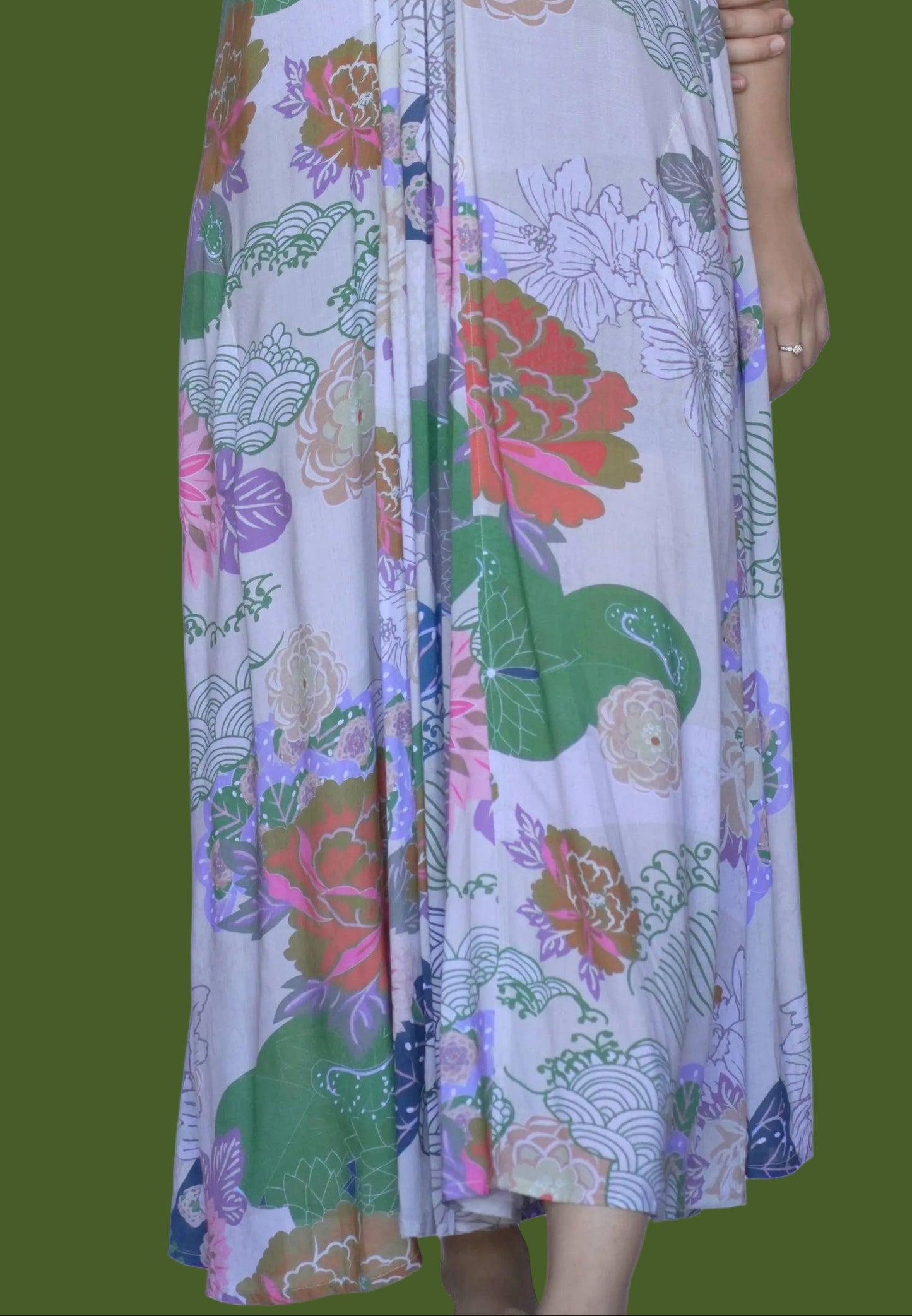 Woman wearing a colorful floral dress against a white background