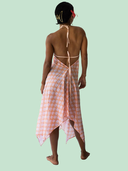 Woman wearing a pink and white patterned dress on a white background