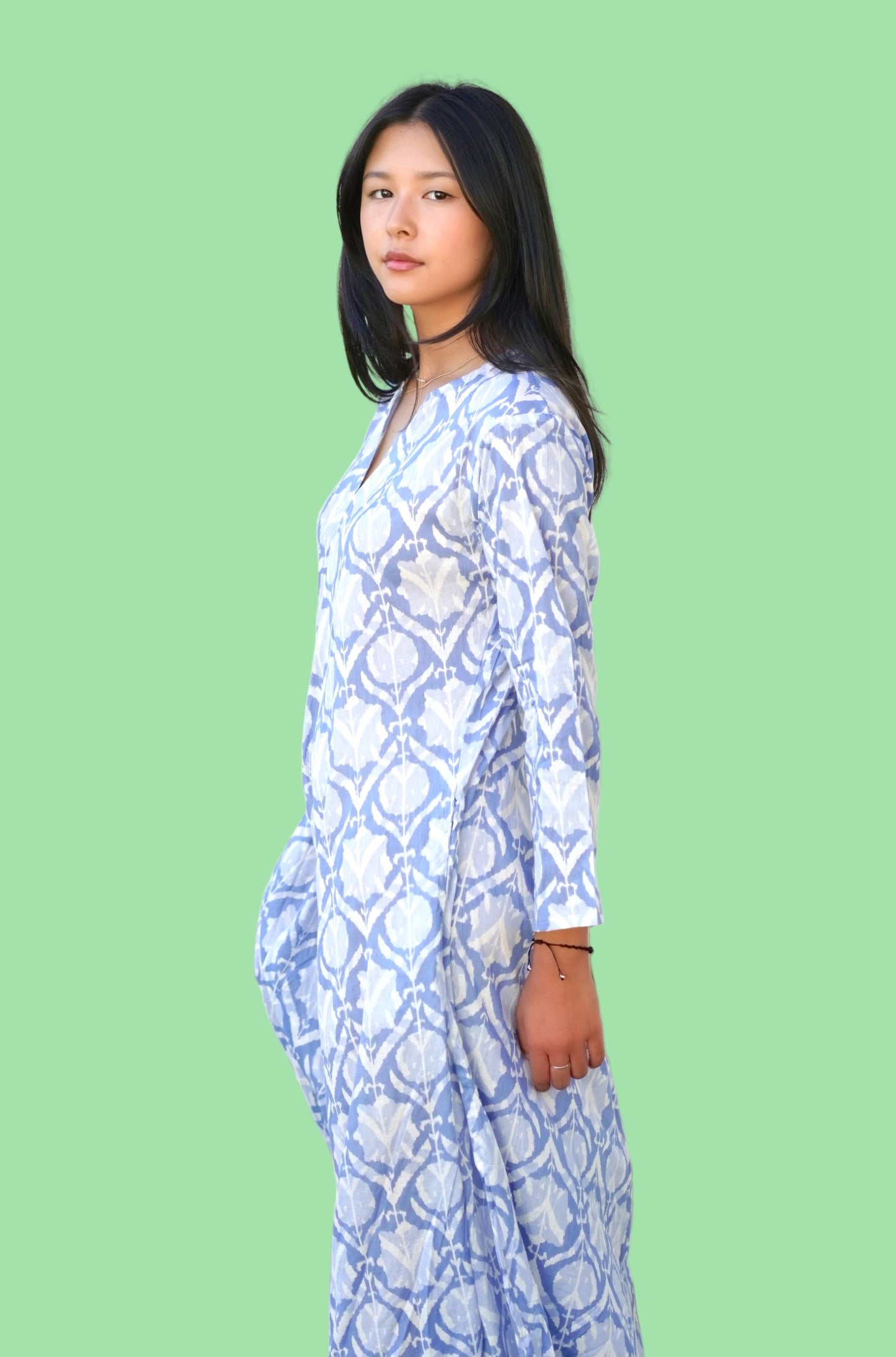 Woman wearing a blue patterned dress against a white background