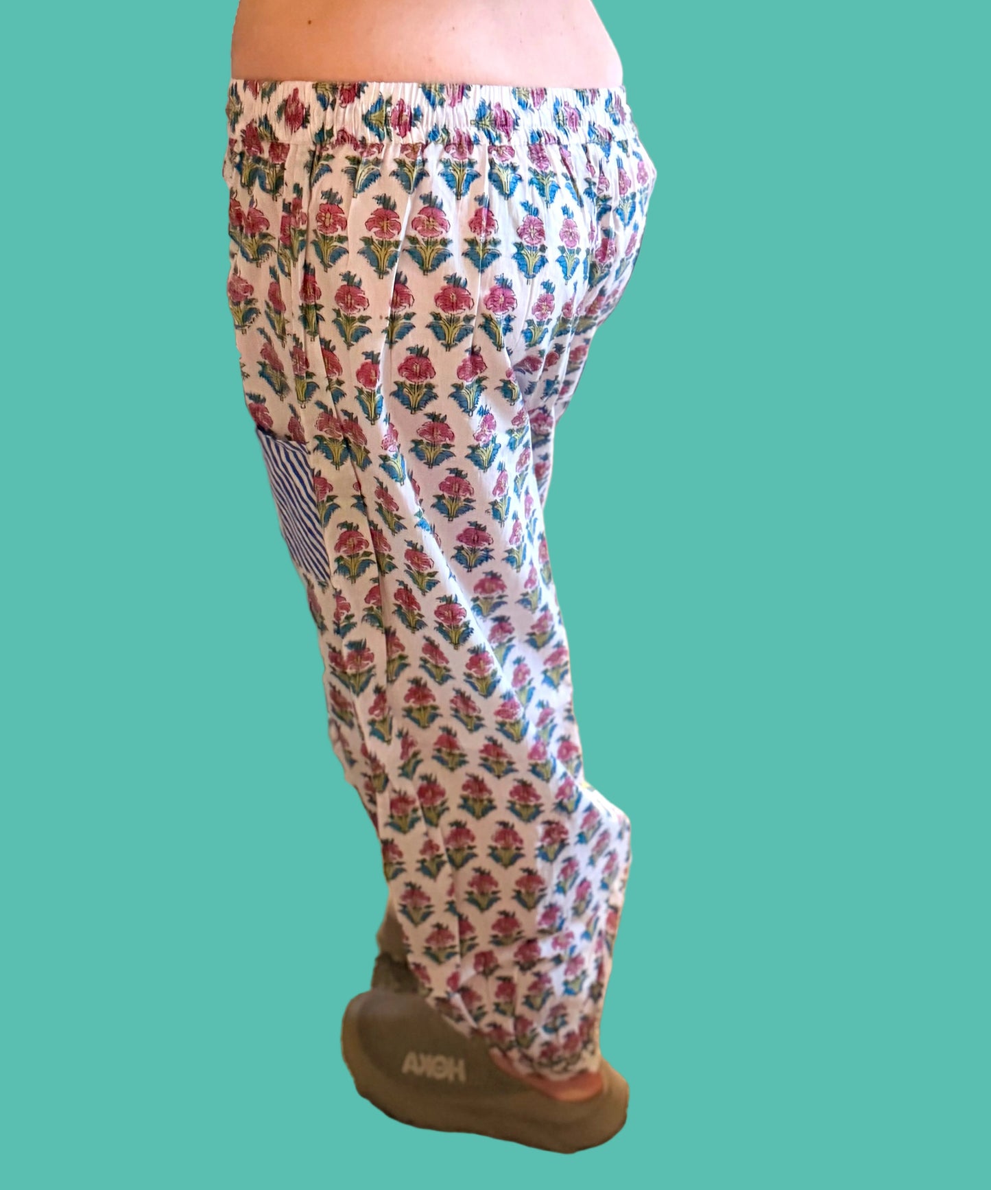 Person wearing patterned pants in a cluttered room