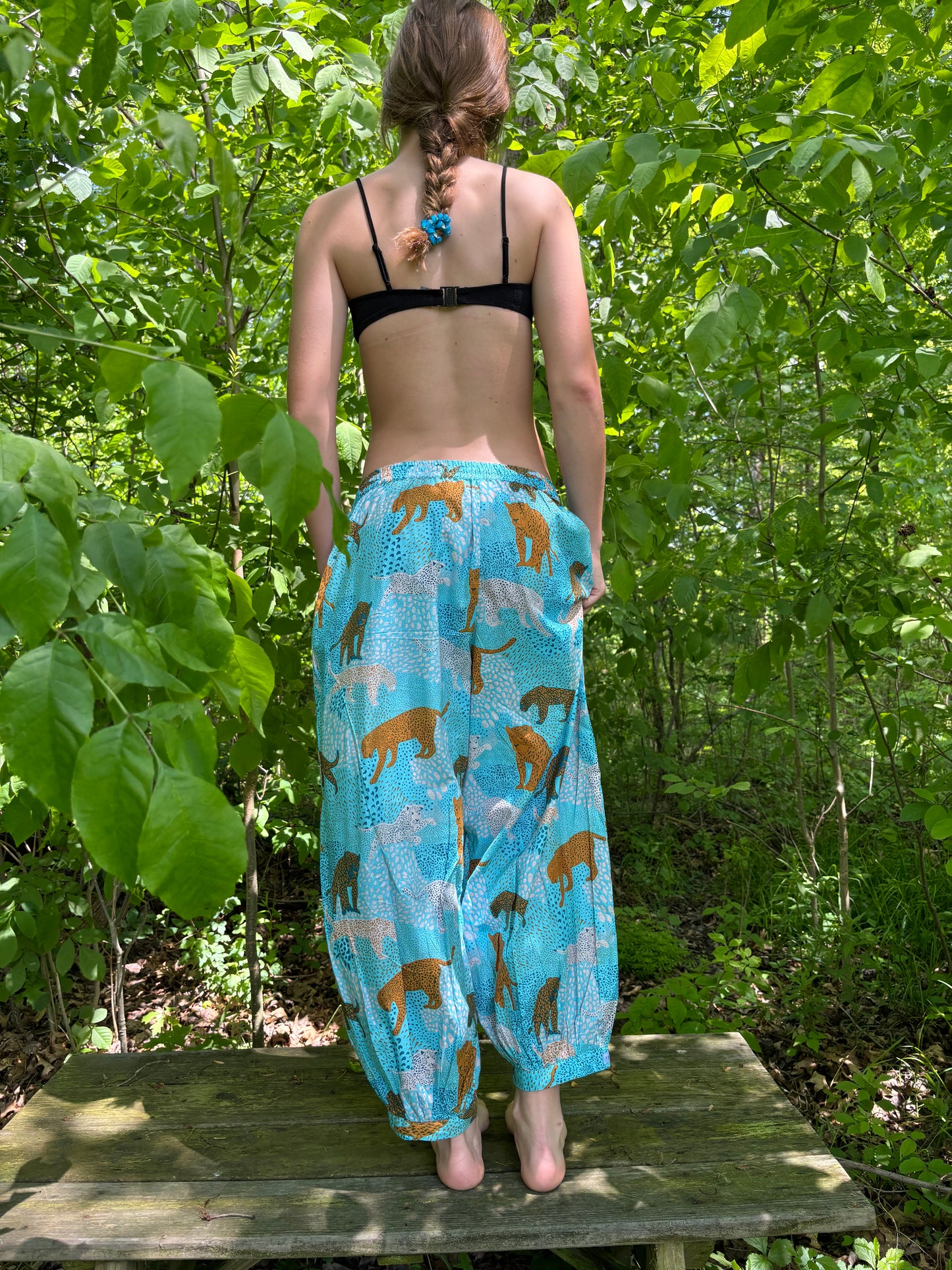 Person wearing a blue patterned bag outdoors with greenery in the background
