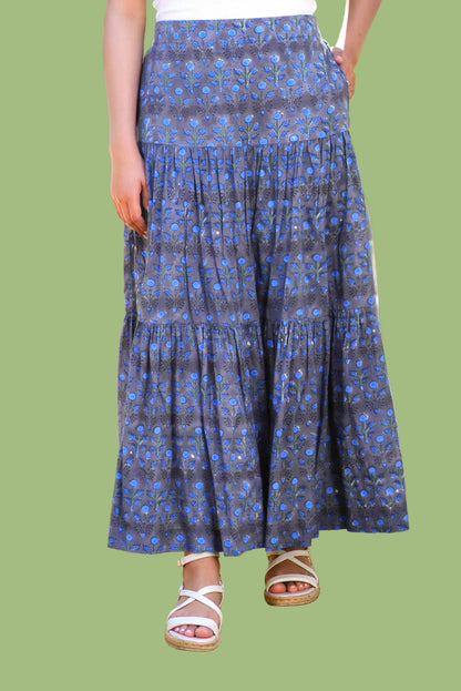 Person wearing a blue patterned skirt outdoors