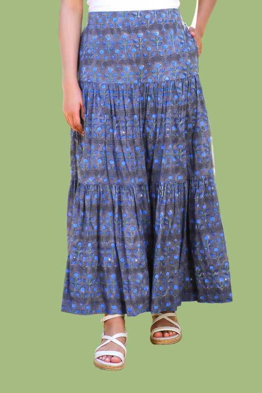 Person wearing a blue patterned skirt outdoors