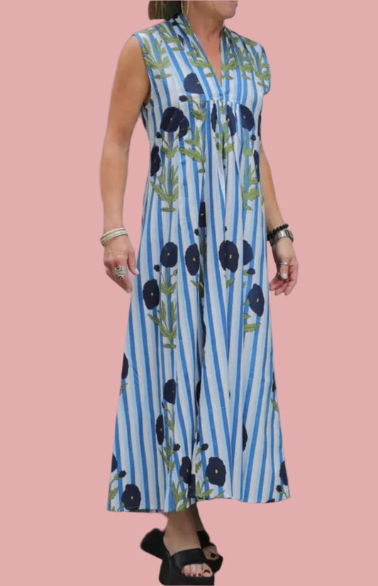 Woman wearing a blue and white striped dress with black floral patterns on a pink background
